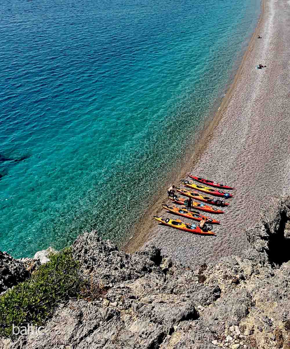 Clear water beach with kayaks on Rhode island, Greece