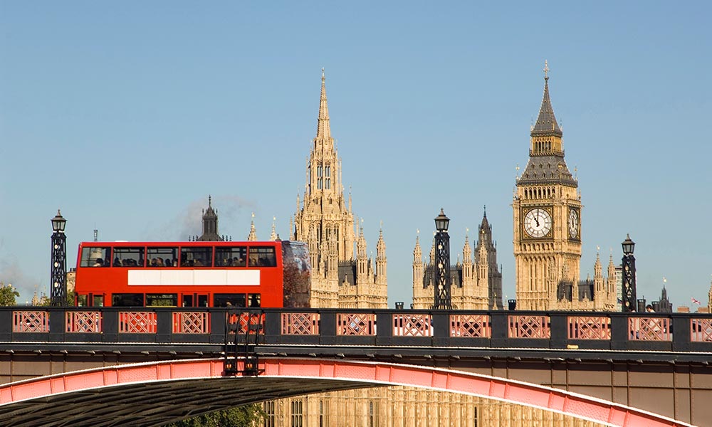 Bridge over river Thames in London with red bus and Big Ben in background