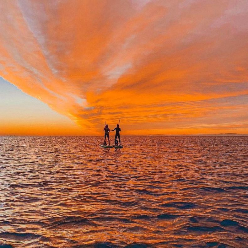 Watch the sun rises over the sea on a sup board