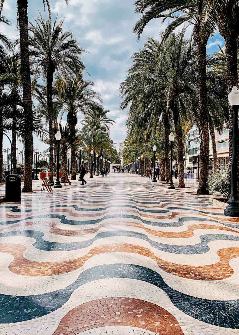 The iconic Explanada de España is tiled with mosaic tiles set in a pattern that mimics the waves of the Mediterranean