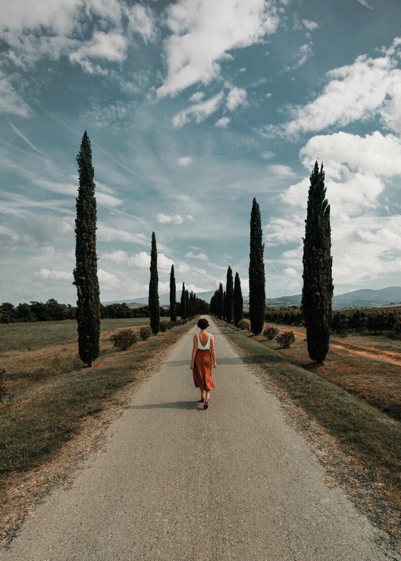 Woman walking through the alley in the Province of Siena, Tuscany