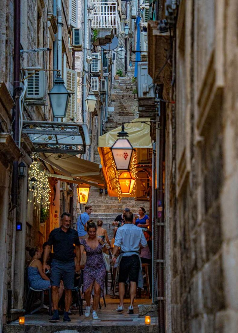 People enjoy an evening on a narrow Dubrovnik street