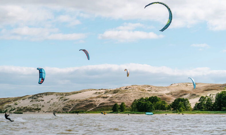 A group of people enjoy the thrill of kiteboarding in Lithuania