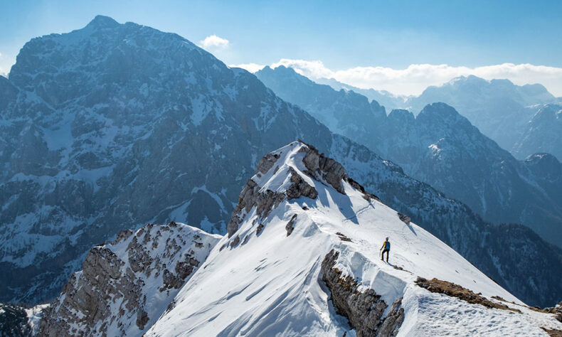 Man standing on the peak at the Kranjska Gora, which is an alpine resort in northwestern Slovenia