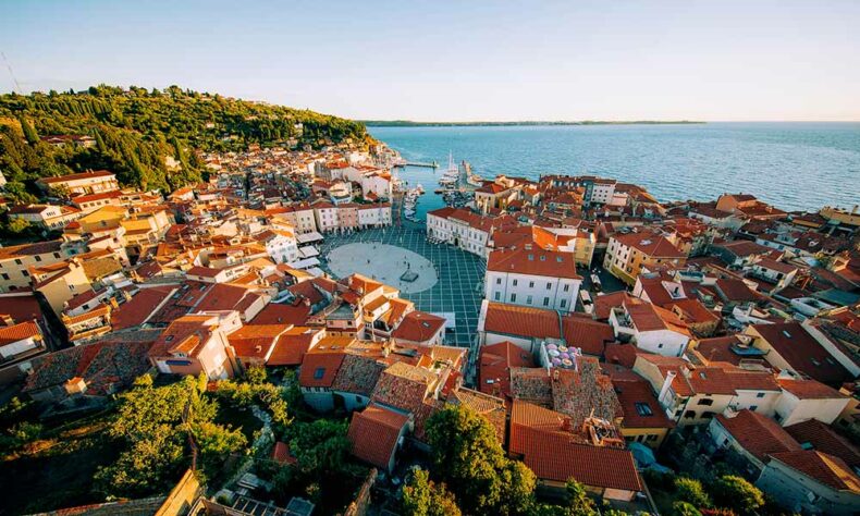 Red rooftop houses surround Tartini Square in Piran