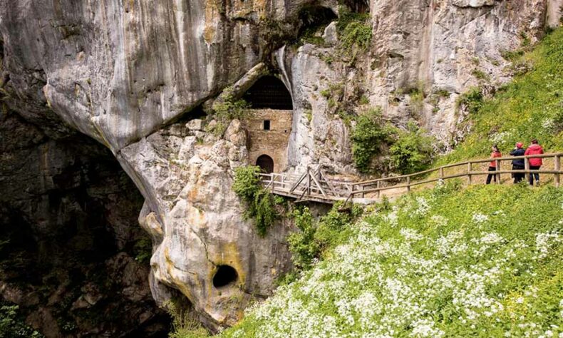 Walk through the hidden tunnel under the Predjama Castle with a guide