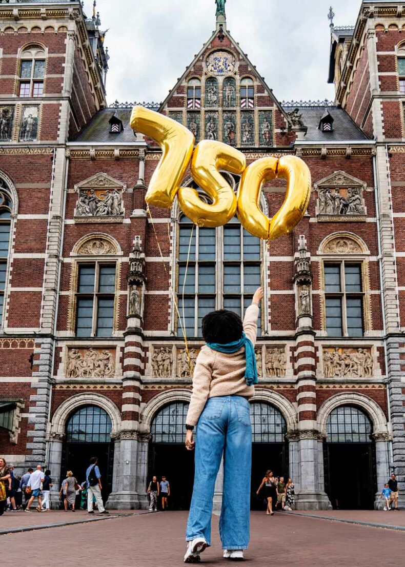 Woman holding festival balloons at the entrance of Rijksmuseum