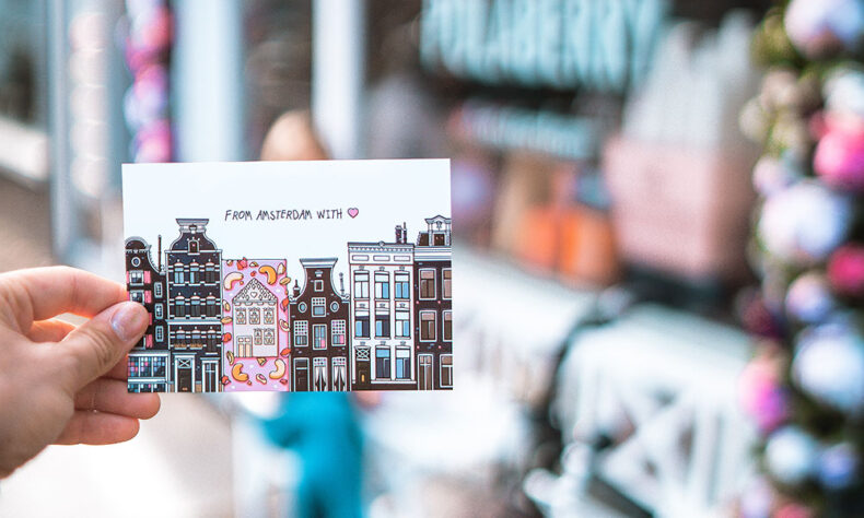 Woman holding postcard - From Amsterdam with love