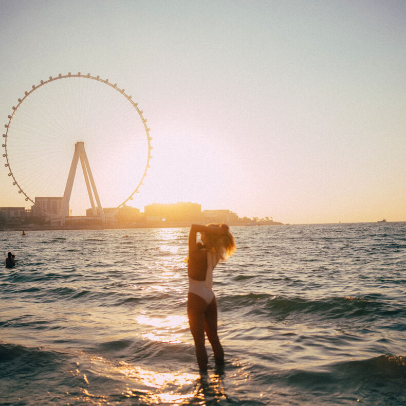 Woman standing in water with the Ain Dubai- World's Tallest Observation Wheel in the background
