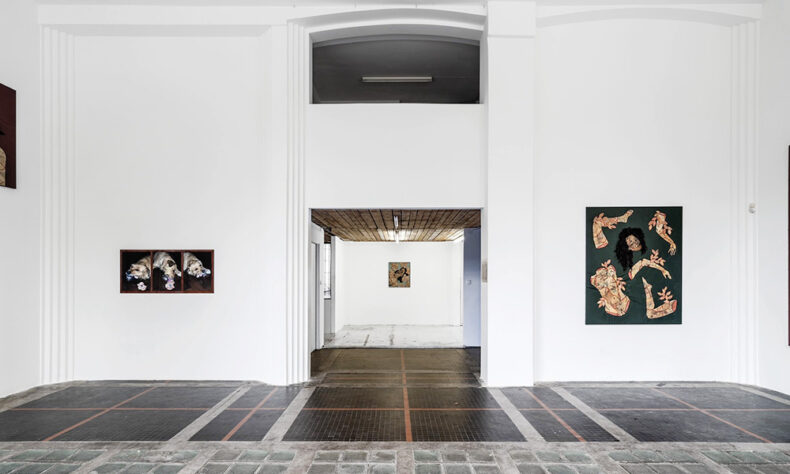 Interior view of Galeria Raster in Warsaw, featuring a minimalist white exhibition space with contemporary paintings on the walls