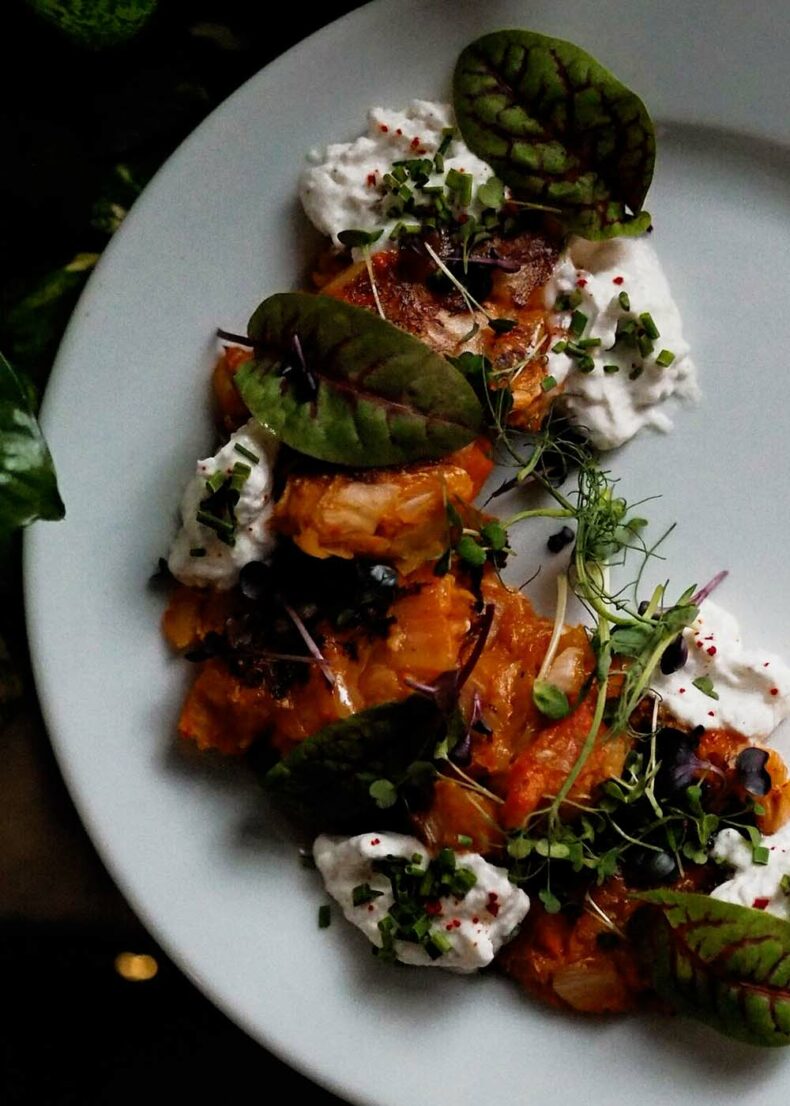 Pancakes with kimchi and sour cream served at NO TU OliDeli in Warsaw, showcasing the city’s creative plant-based dining scene
