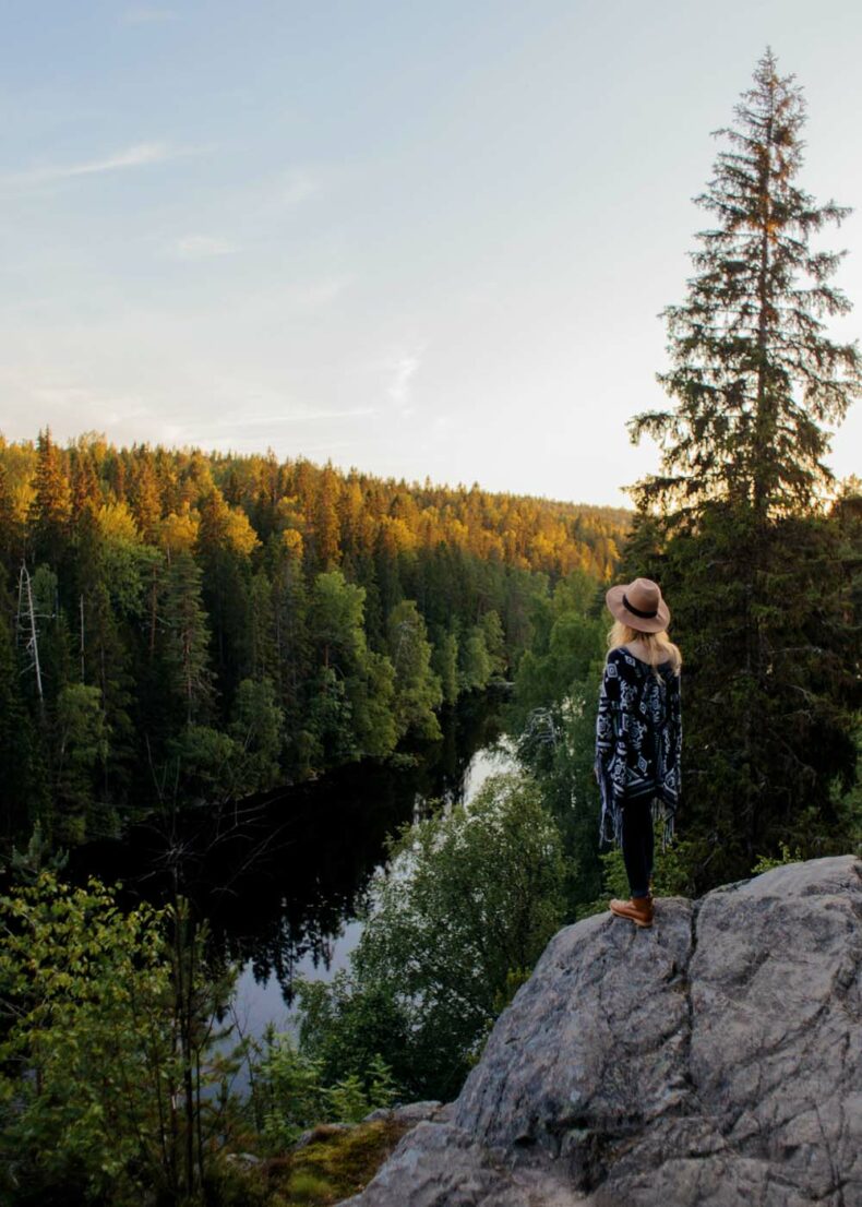 Woman standing on a rock at the Helvetinjärvi National Park near Tampere