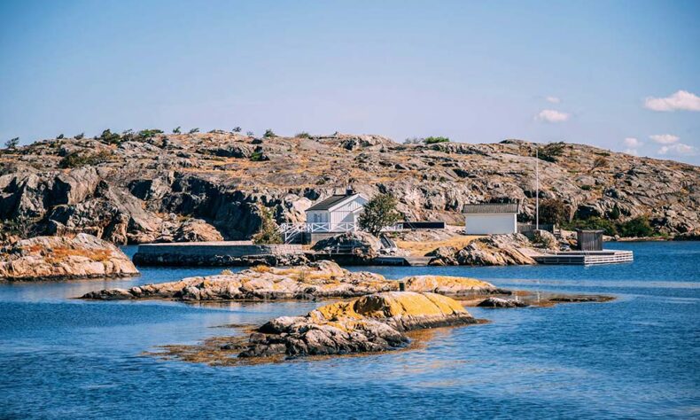 A small white private house on a rocky island in Norway during daytime