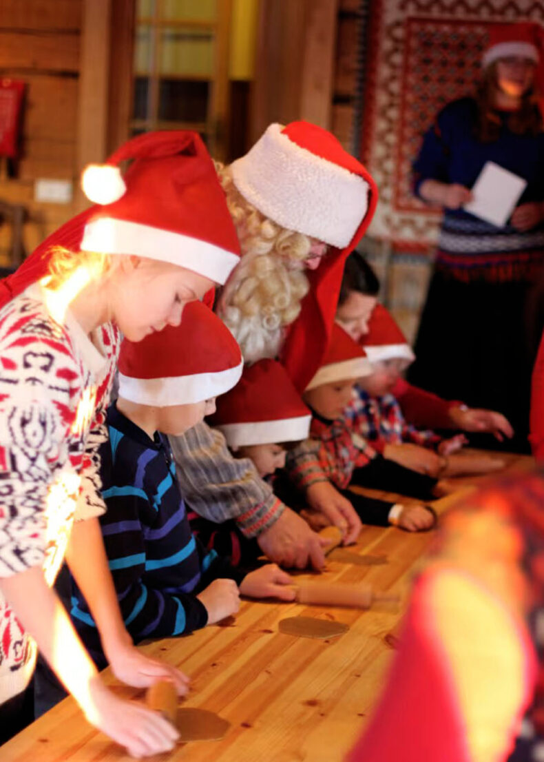 Kids baking gingerbread with Father Christmas and Mrs Claus at the Santa's Cottage