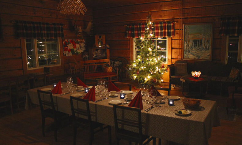 Room with Christmas tree and decorated table to experience the magic of a storybook Christmas in Kuusamo