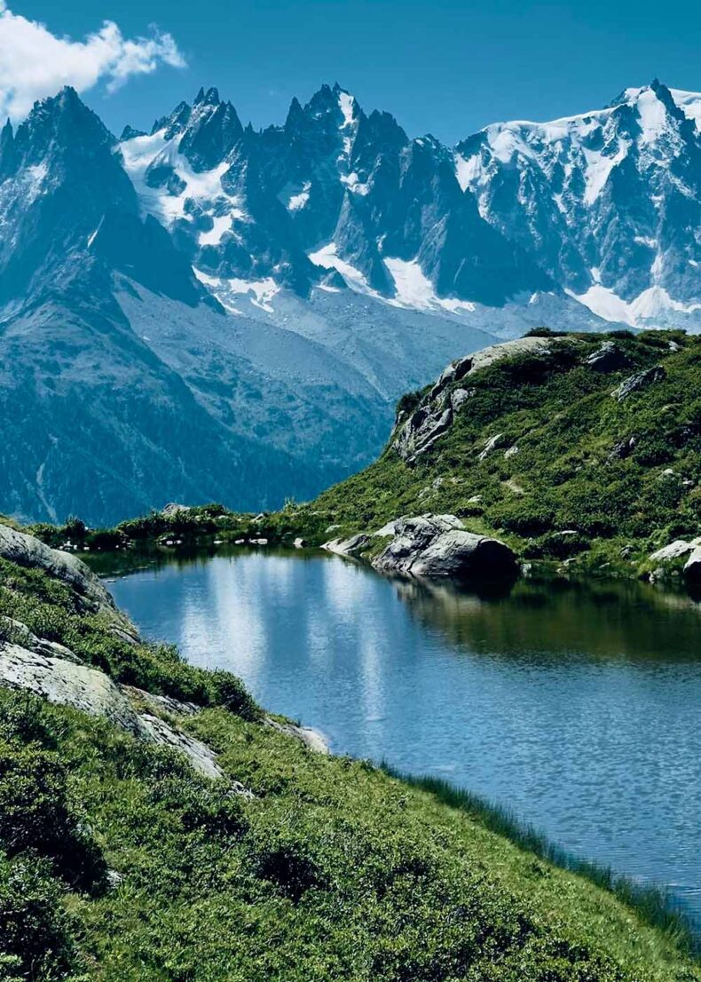 Snow-capped jagged mountains reflected in a tranquil alpine lake