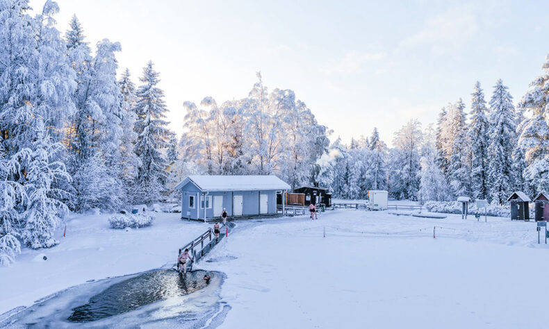 Warming up in sauna and afterwards step into ice-swimming hole surrounded by amazing winter view